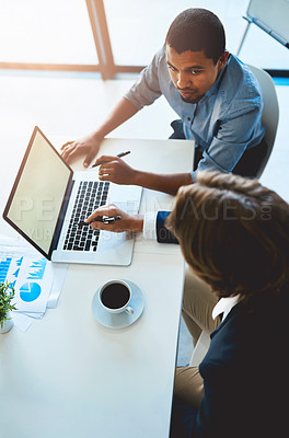 Buy stock photo High angle shot of two young colleagues using a laptop together in the office