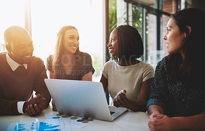 Buy stock photo Shot of a group of young businesspeople working together around a laptop in the office
