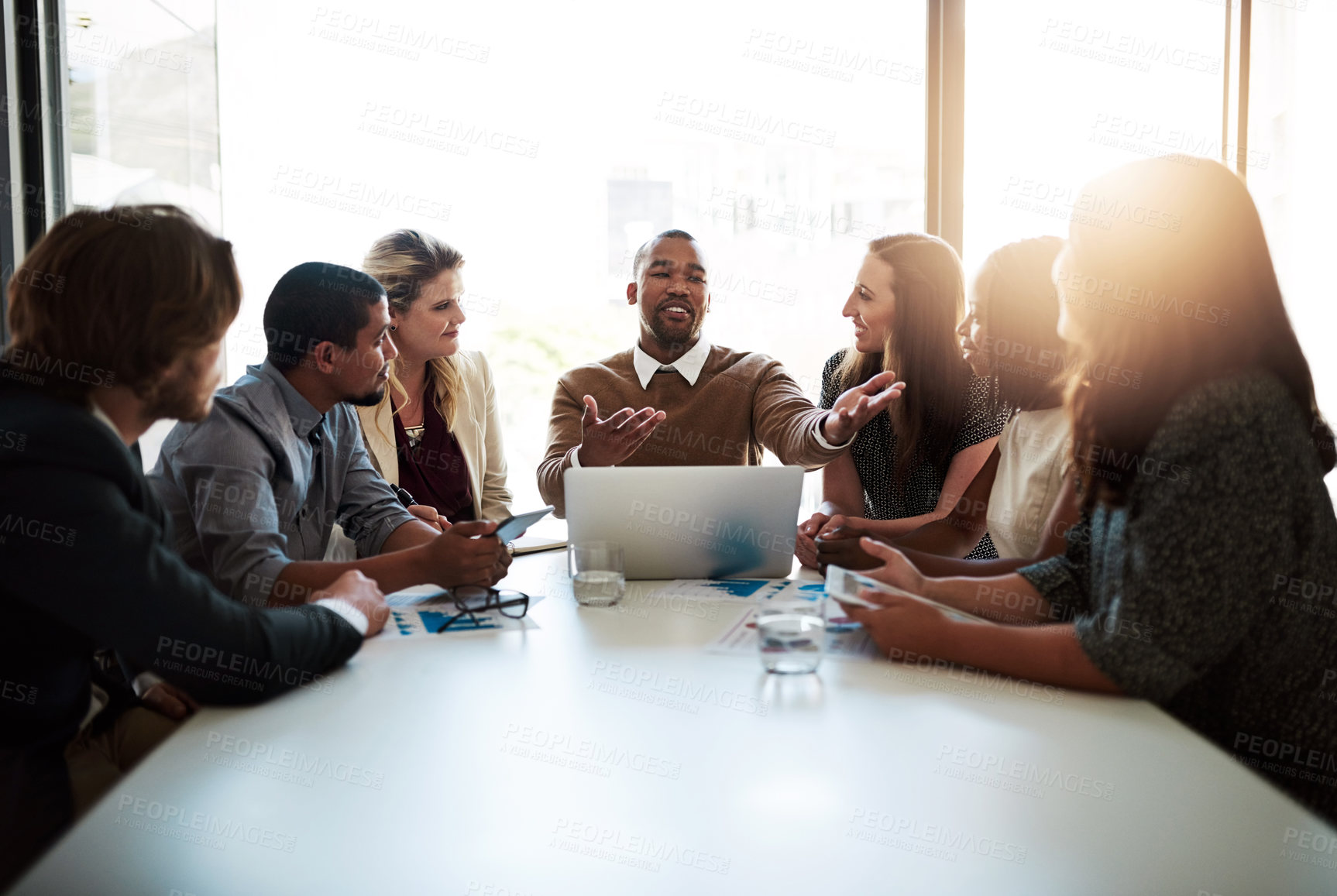 Buy stock photo Shot of a young businessman praising one of his coworkers during a meeting in the office