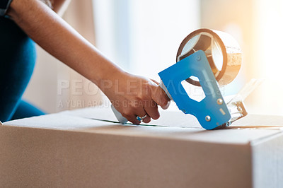 Buy stock photo Shot of an unrecognizable young woman closing a cardboard box with tape at home