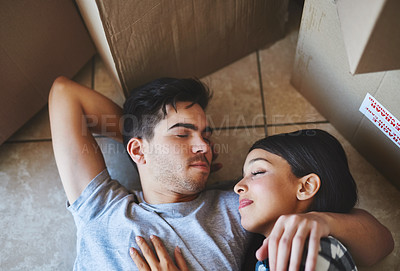 Buy stock photo Couple, rest and relax on floor in new home with boxes for property investment and moving day for homeowner. Achievement, people and dream house purchase with top view, sleeping and mortgage sale