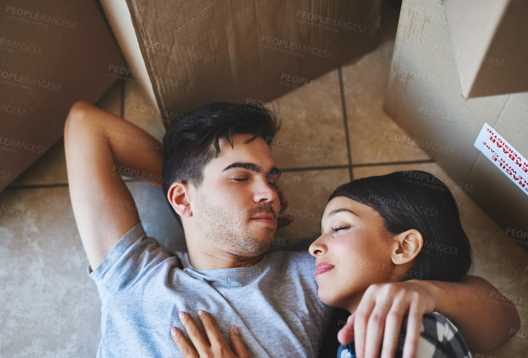 Buy stock photo Couple, rest and relax on floor in new home with boxes for property investment and moving day for homeowner. Achievement, people and dream house purchase with top view, sleeping and mortgage sale
