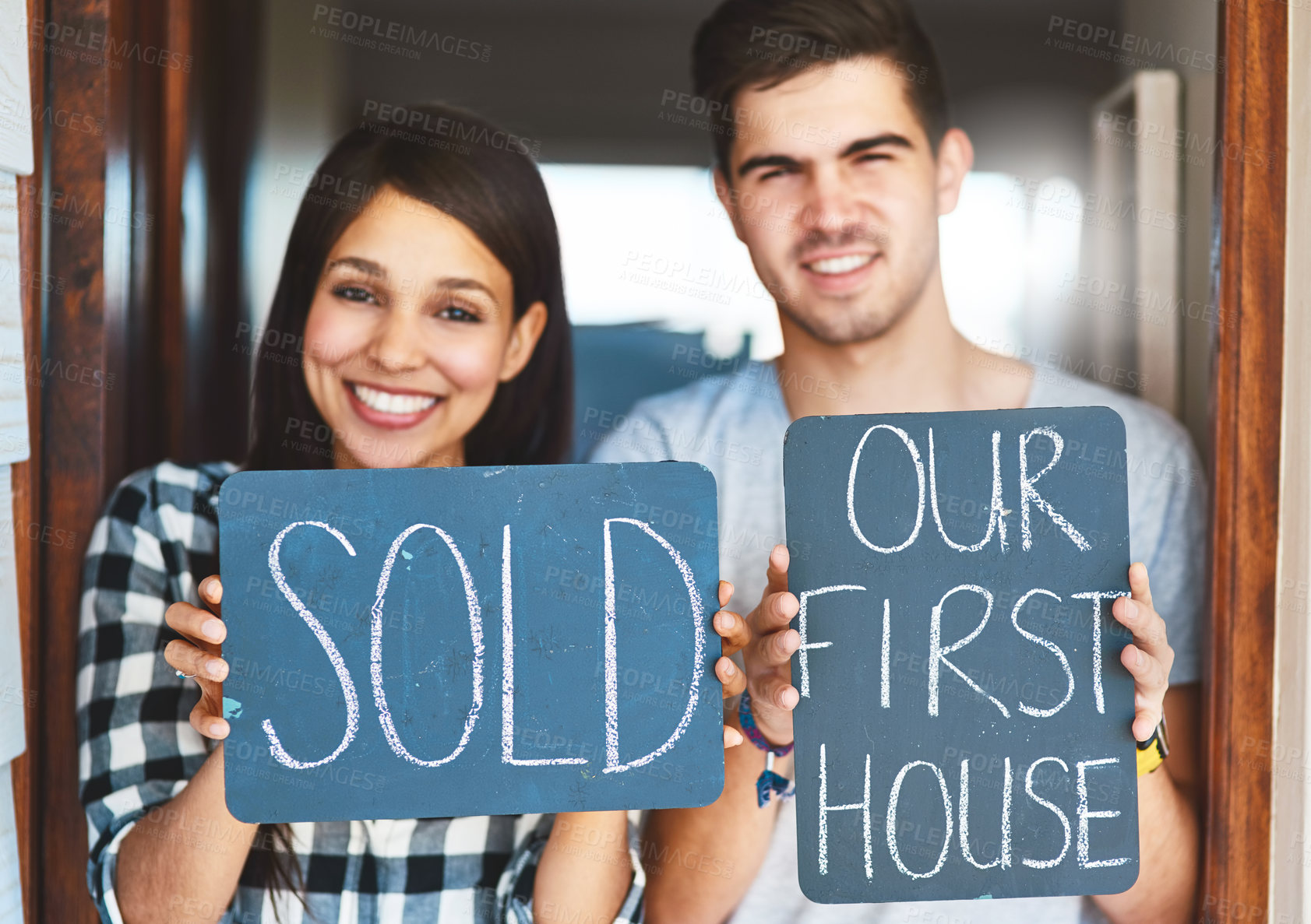 Buy stock photo Couple, sold sign and portrait by door of new house with smile, property investment and homeowner. Achievement, interracial people and dream home purchase with success board in doorway for mortgage sale