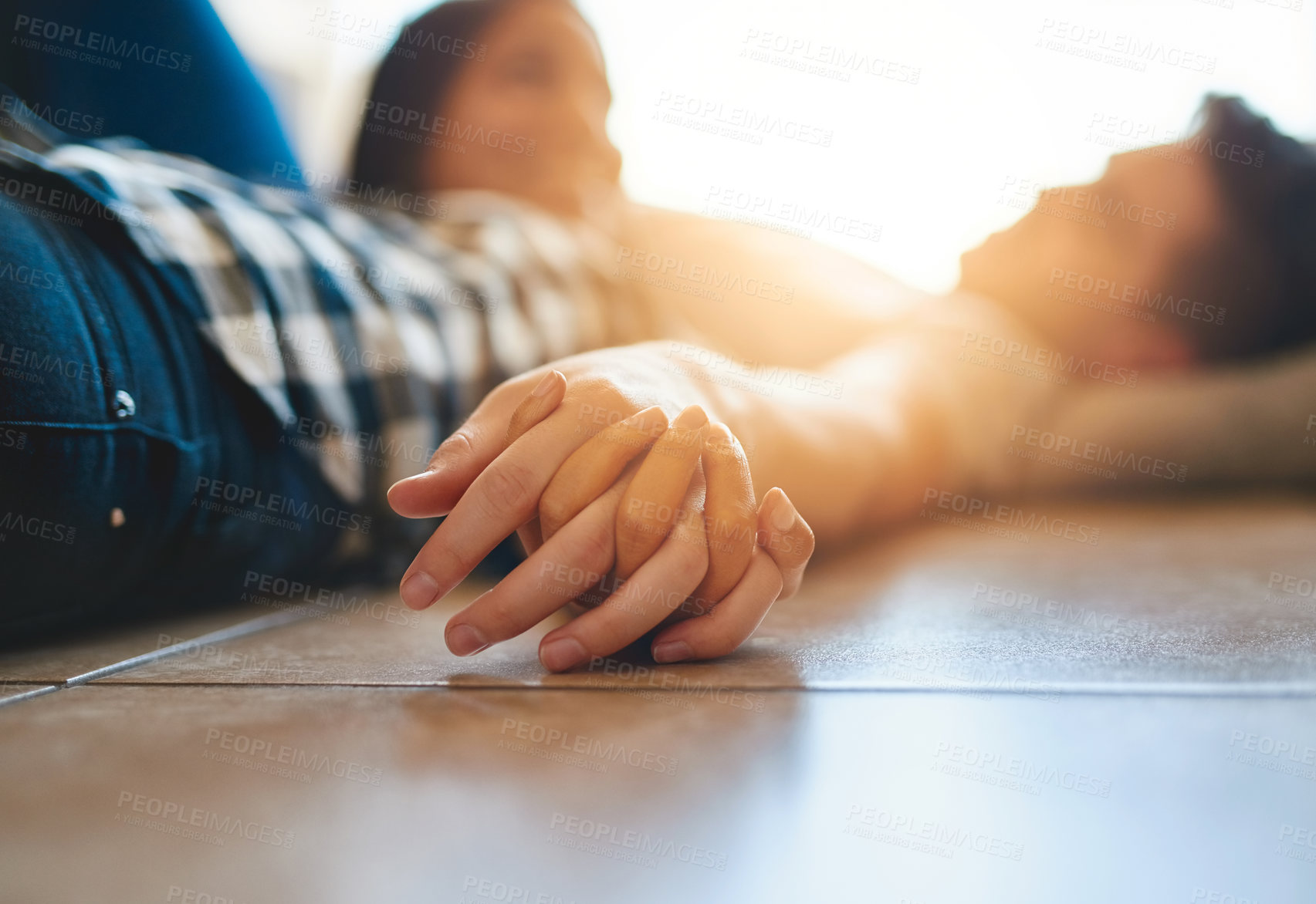 Buy stock photo Couple, holding hands and relax on floor for love, bonding and support or security in relationship. People, connection and commitment in marriage, together and affection for trust on ground of home