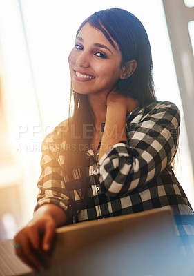 Buy stock photo Portrait of a happy young woman leaning on a cardboard box on moving day