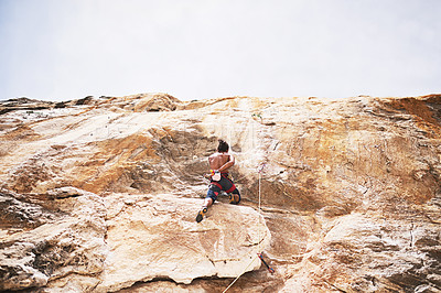 Buy stock photo Rock climbing, mountain and man in nature for sport, fitness or adventure on cliff. Rope, explore or safety with harness and equipment for male person, hobby or rocks for challenge on boulder outside