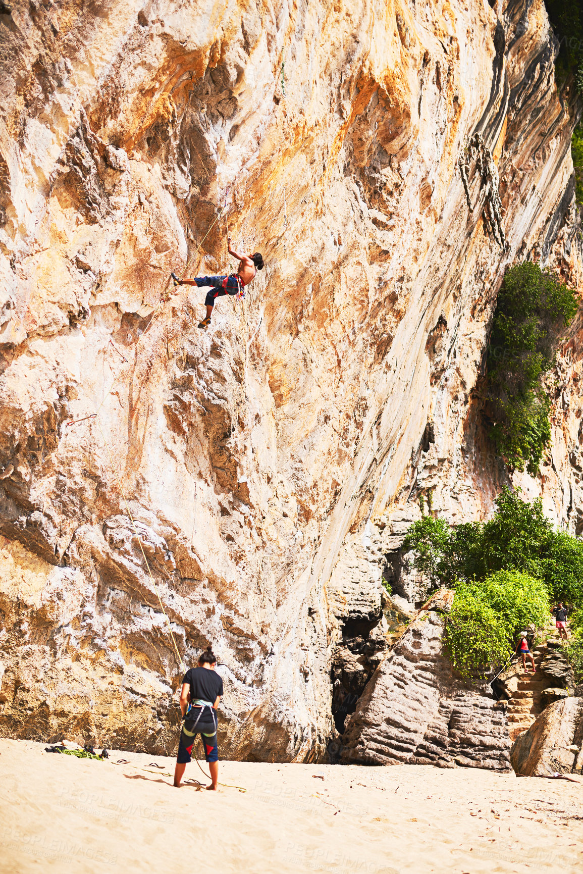 Buy stock photo Travel, rock climbing and people with rope by cliff for adventure, adrenaline or fitness challenge. Extreme sports, exercise and man with instructor for harness gear for mountain activity on holiday.