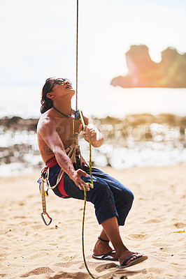 Buy stock photo Rock climbing, nature and man with rope by beach for training, exercise and extreme sports outdoors. Cliff, travel and person with harness, equipment and gear for adventure, fitness and challenge