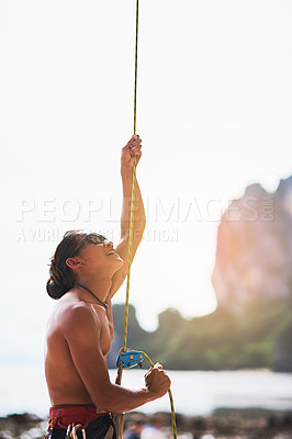 Buy stock photo Rock climbing, nature and man with rope for training, exercise and extreme sports on outdoor cliff. Mountain, travel and person with harness, equipment and gear for adventure, fitness and challenge