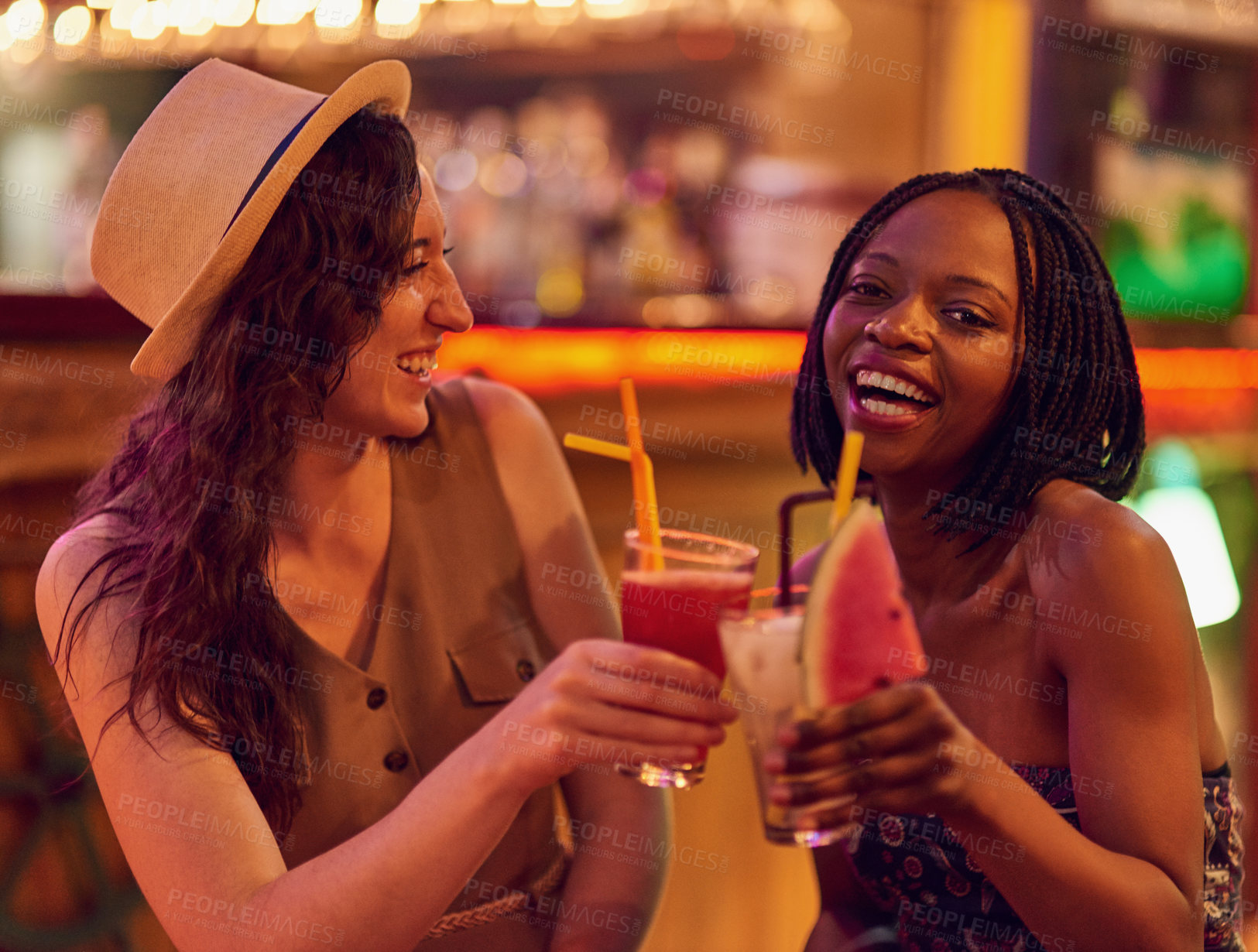 Buy stock photo Cropped shot of two young friends having drinks together in a bar