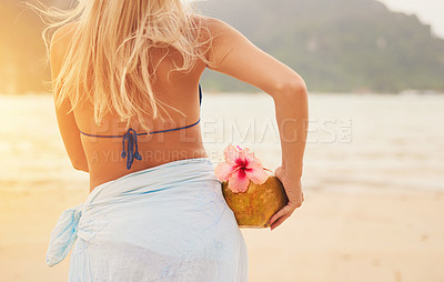 Buy stock photo Bikini, woman and coconut cocktail at beach on vacation, travel and summer holiday on island in Greece. Back view, fruit drink and girl at sea to relax in nature with healthy organic hibiscus flower