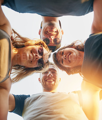 Buy stock photo Low angle shot of a group of happy young friends posing outside