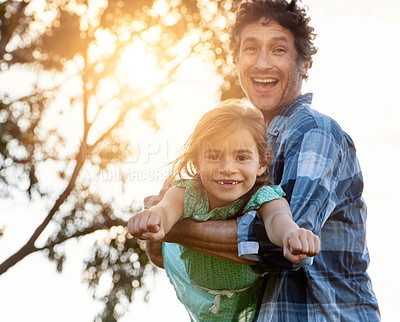 Buy stock photo Portrait of a happy father playfully carrying his daughter during a fun day outdoors