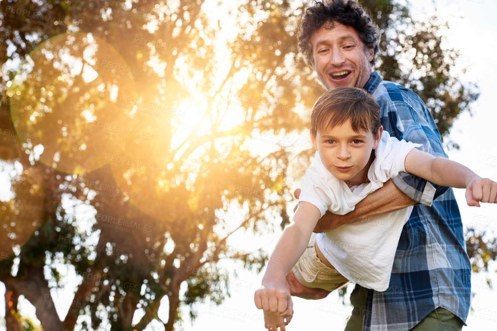 Buy stock photo Father, portrait and son playing plane outdoor with happiness for summer or holiday as family. Man, boy and smile by tree in garden with fun for freedom, love and fun together as superhero flying
