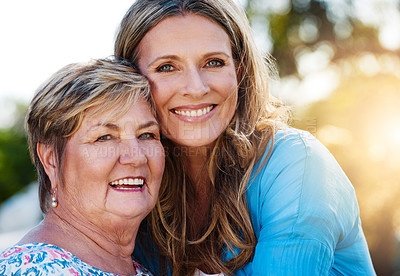 Buy stock photo Portrait of a happy mature woman hugging her mother outdoors
