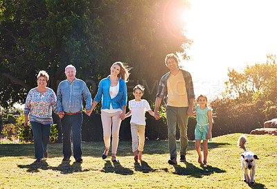 Buy stock photo Portrait of three generations of family walking hand in hand outdoors