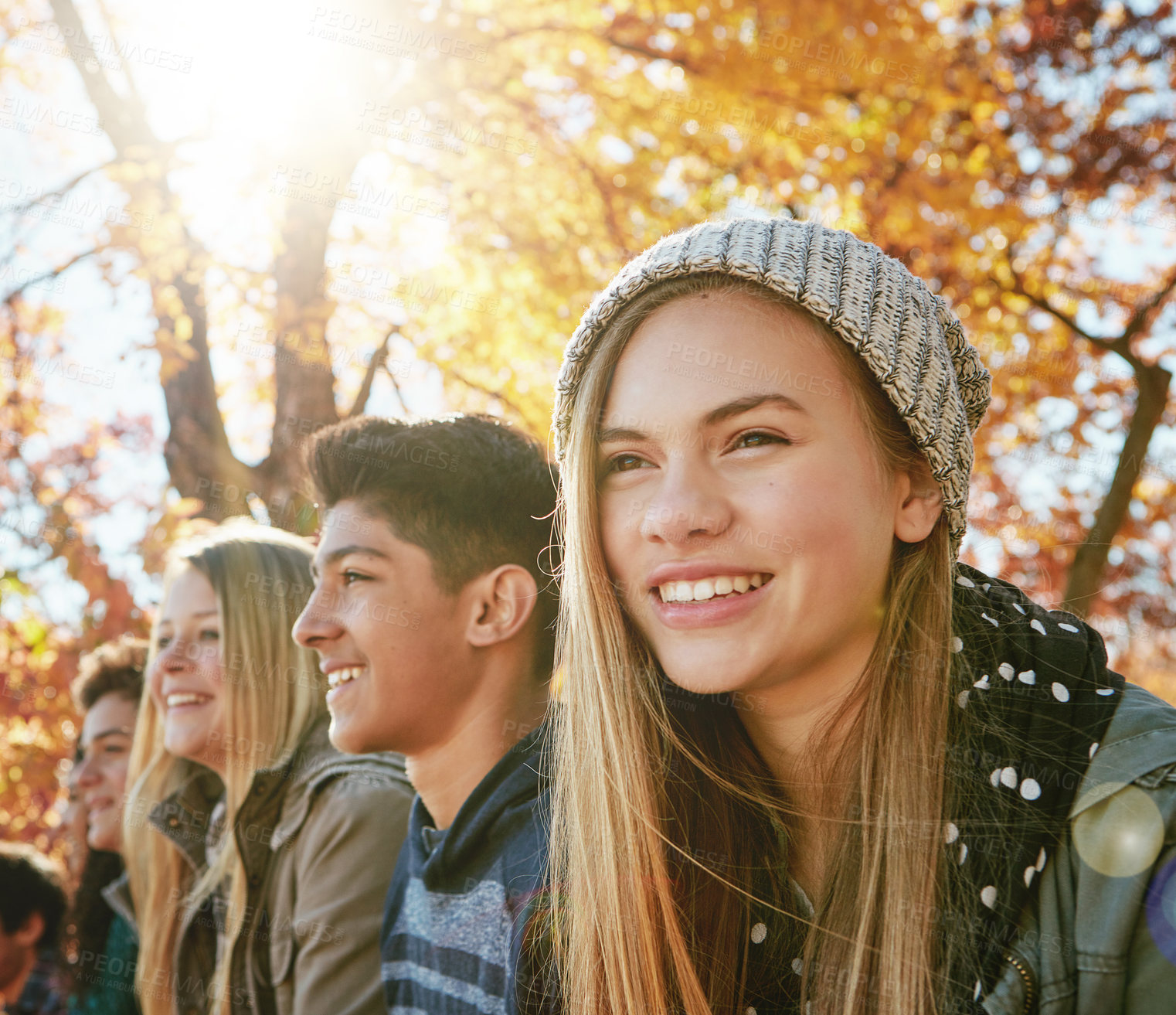 Buy stock photo Happy, row and teenagers outdoor in park for relaxing day on summer vacation of semester break, together and bonding. Group, friends and trees in garden on holiday in New Zealand and lens flare.