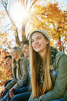 Buy stock photo Shot of a group of young friends enjoying a day at the park together