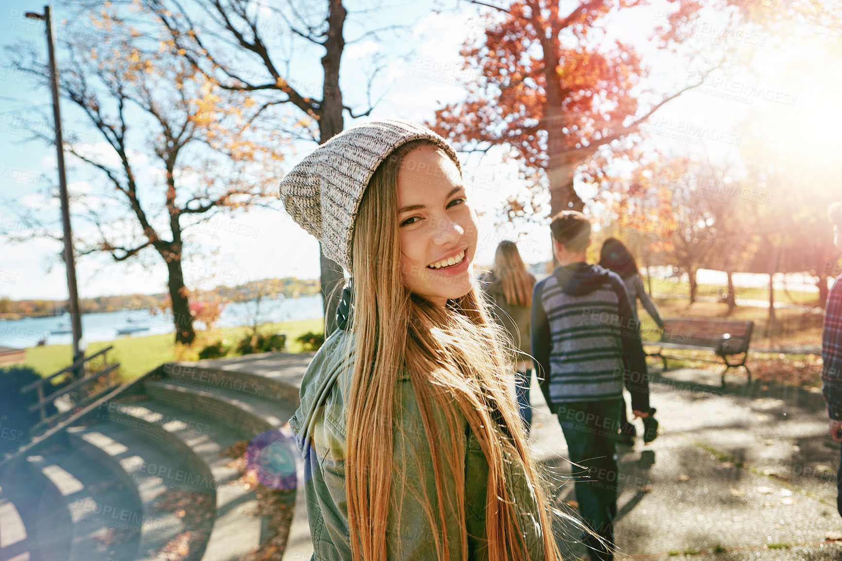 Buy stock photo Teenager, girl in nature with friends and walk in park with autumn and sunshine, wellness with happy in portrait. Youth outdoor, enjoy fresh air and bonding with smile, flare with adventure or travel