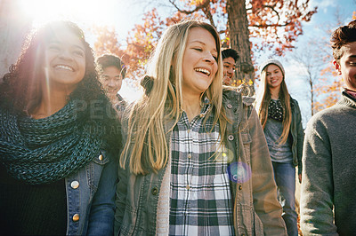 Buy stock photo Teenager, walking and talking with friends in park, nature or social group outdoor together with diversity. Happy, teens or kids relax in fall with a joke, best friend or conversation in community