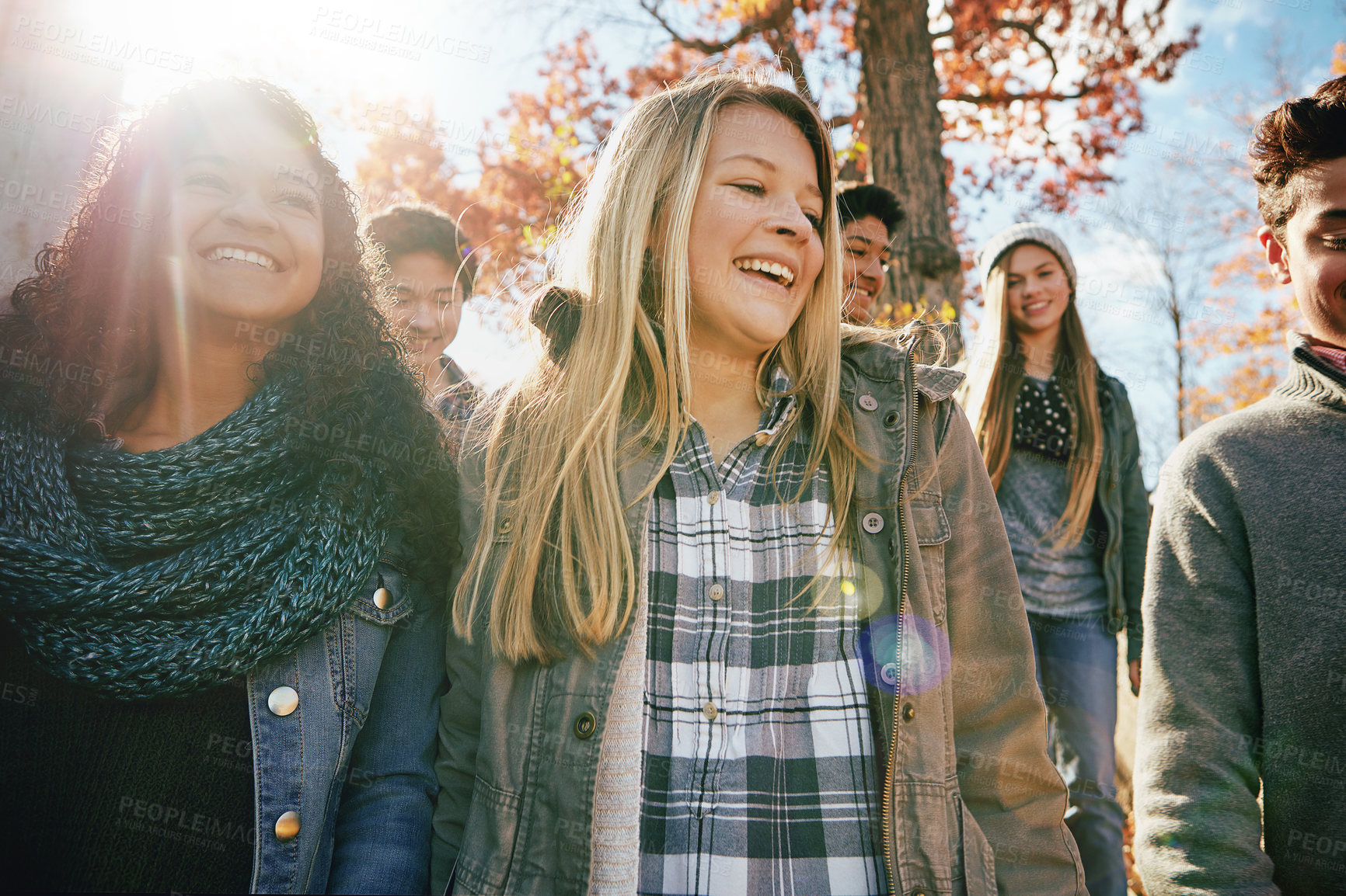 Buy stock photo Teenager, walking and talking with friends in park, nature or social group outdoor together with diversity. Happy, teens or kids relax in fall with a joke, best friend or conversation in community