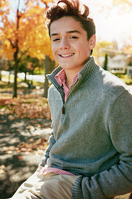 Buy stock photo Portrait of a happy teenage boy enjoying an autumn day in the park