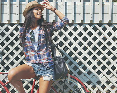 Buy stock photo Shot of a beautiful young woman riding her bike in the park