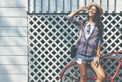 Buy stock photo Shot of a beautiful young woman riding her bike in the park