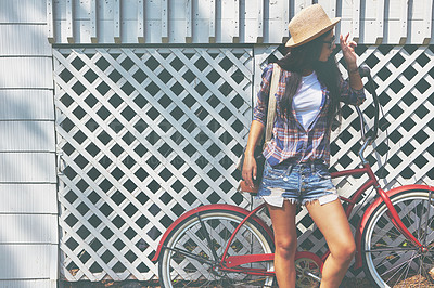 Buy stock photo Shot of a beautiful young woman riding her bike in the park