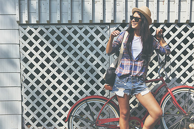 Buy stock photo Shot of a beautiful young woman riding her bike in the park