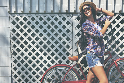 Buy stock photo Shot of a beautiful young woman riding her bike in the park