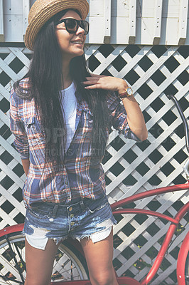 Buy stock photo Shot of a beautiful young woman riding her bike in the park