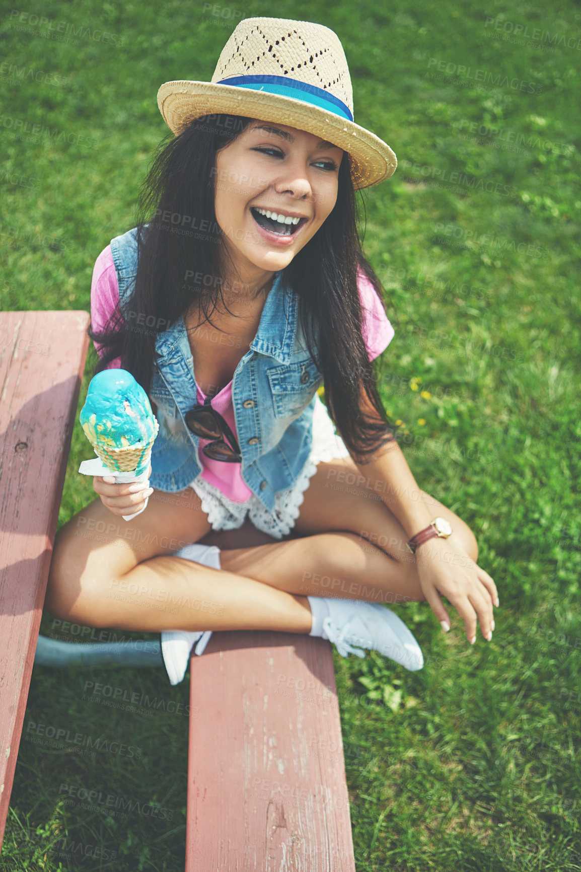 Buy stock photo Shot of an attractive young woman enjoying an ice cream in the park