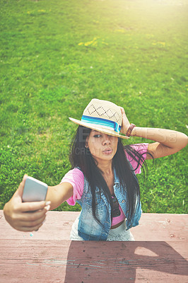 Buy stock photo Outdoor, girl and selfie on bench in park for profile picture on social media or memory of summer vacation in California. Woman, top view and sunshine with photography or pout with hat and attitude.