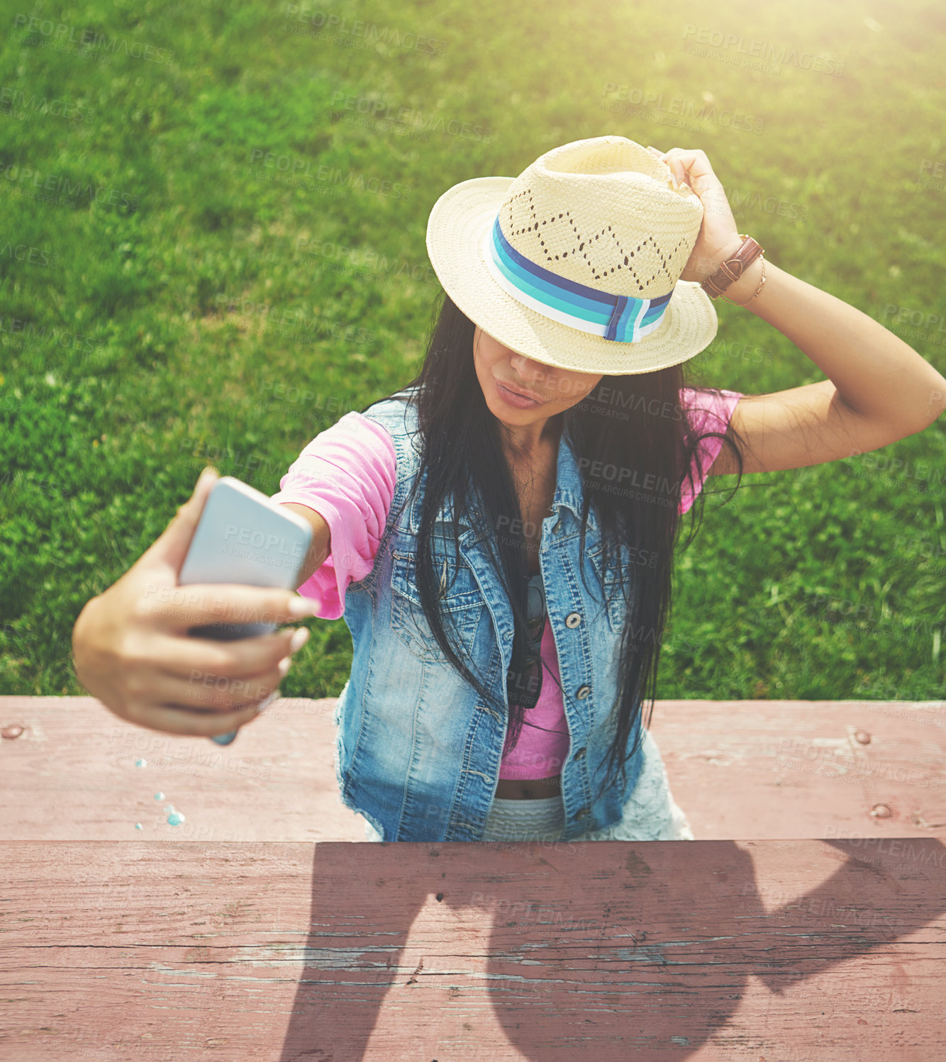 Buy stock photo Shot of an attractive young woman taking selfies while spending a day in the park