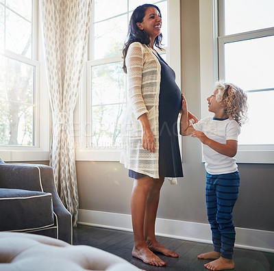 Buy stock photo Shot of a pregnant woman bonding with her little son at home