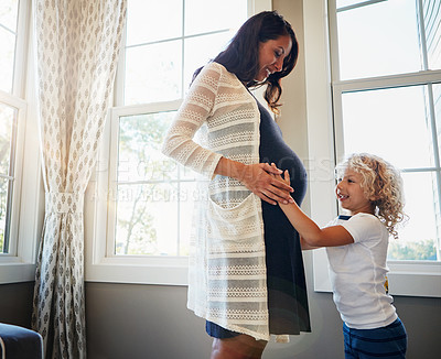 Buy stock photo Cropped shot of a pregnant woman bonding with her little son at home