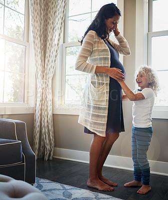 Buy stock photo Shot of a pregnant woman bonding with her little son at home