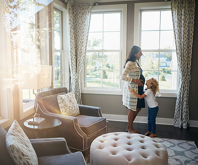 Buy stock photo Shot of a pregnant woman bonding with her little son at home