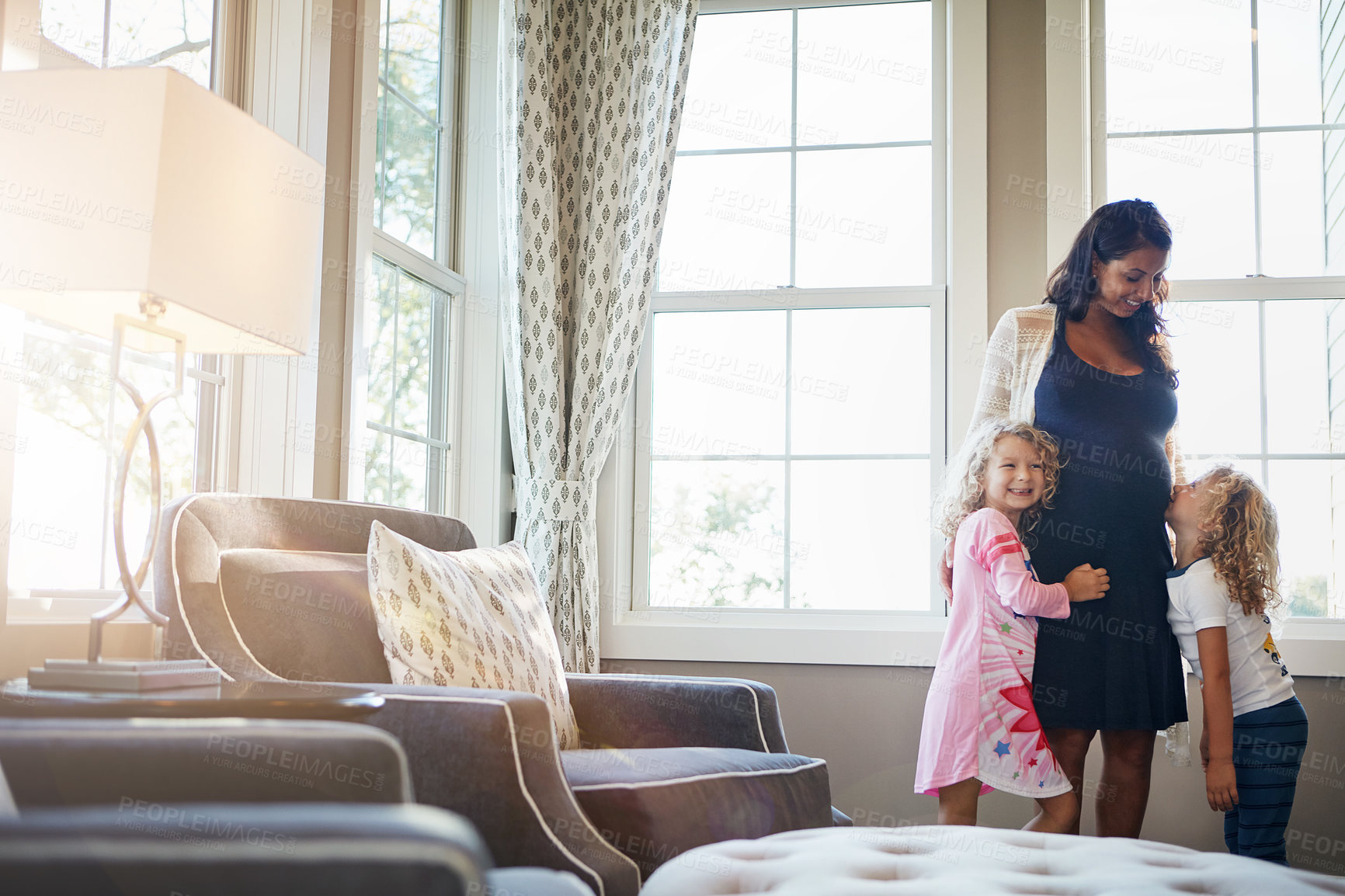 Buy stock photo Shot of a pregnant woman bonding with her little children at home