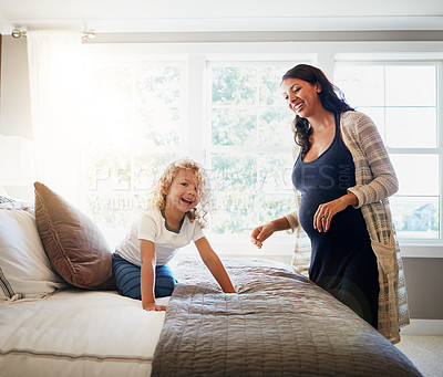 Buy stock photo Shot of a pregnant woman bonding with her little son at home