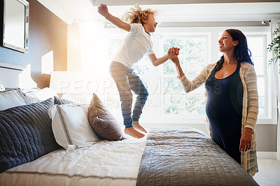 Buy stock photo Shot of a pregnant woman bonding with her little son at home