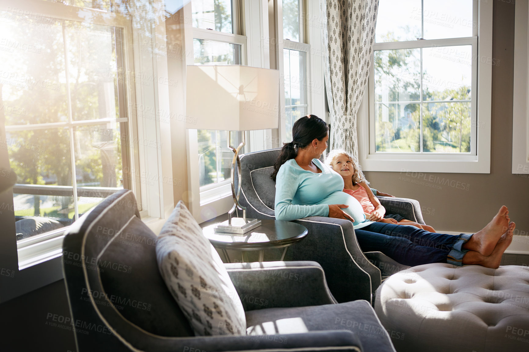 Buy stock photo Shot of a pregnant woman spending time with her daughter at home