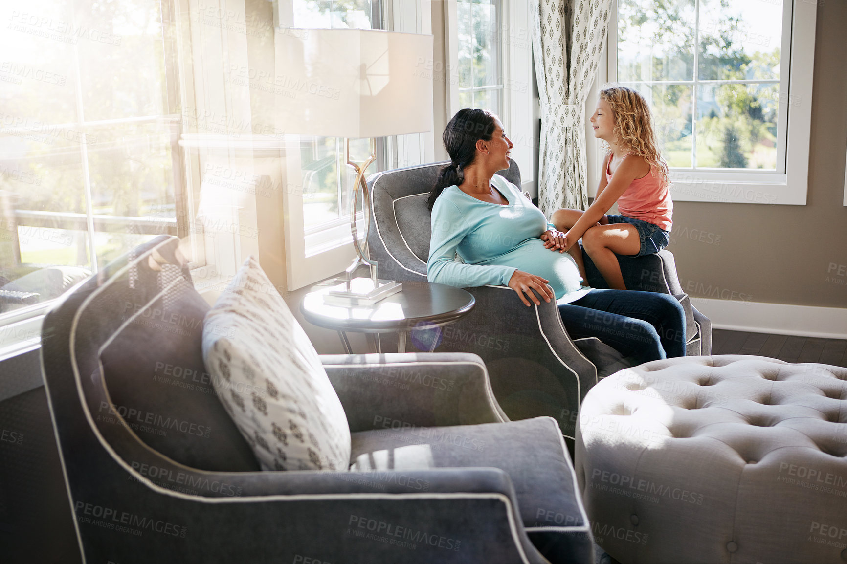 Buy stock photo Shot of a pregnant woman spending time with her daughter at home