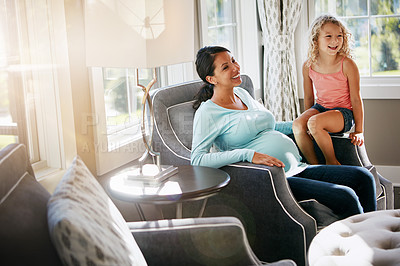 Buy stock photo Shot of a pregnant woman spending time with her daughter at home