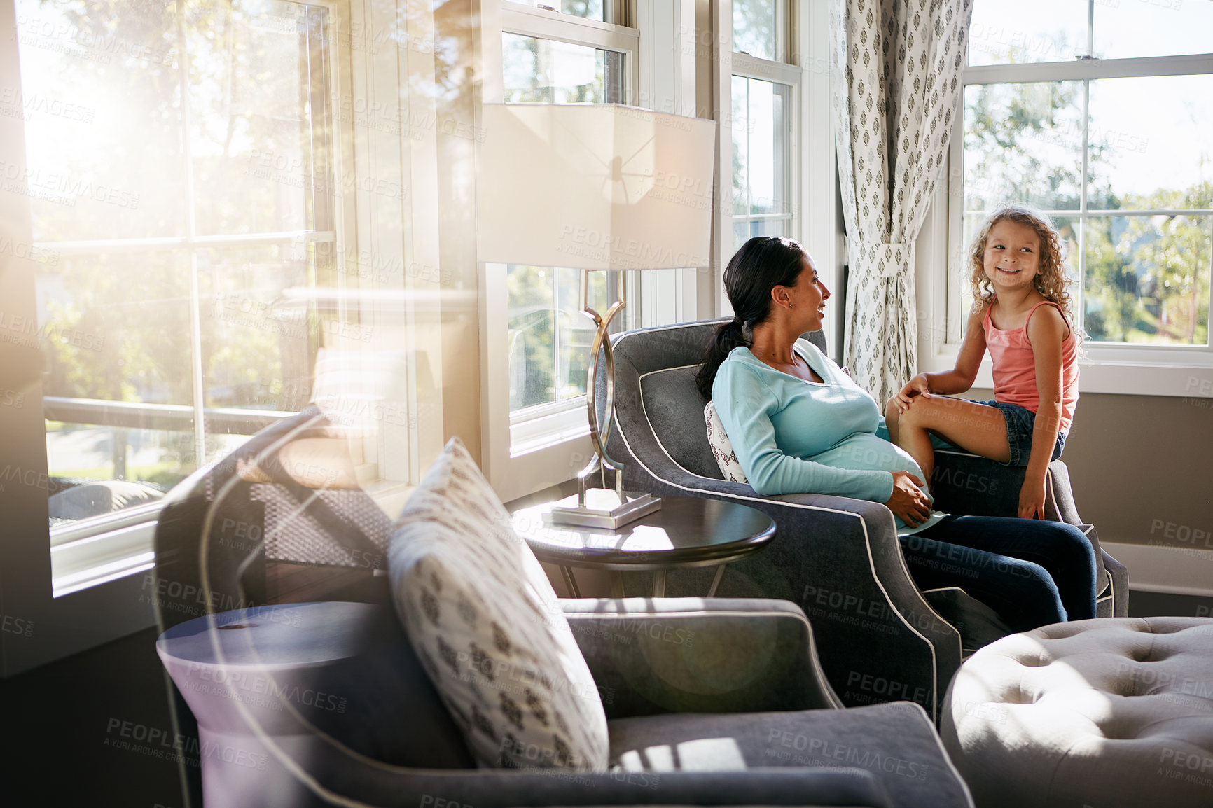 Buy stock photo Shot of a pregnant woman spending time with her daughter at home