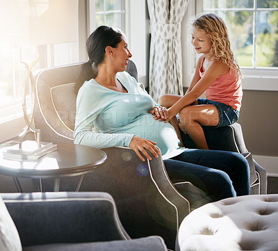 Buy stock photo Shot of a pregnant woman spending time with her daughter at home