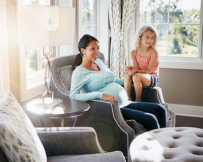 Buy stock photo Shot of a pregnant woman spending time with her daughter at home