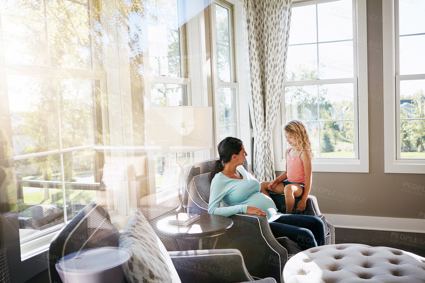 Buy stock photo Shot of a pregnant woman spending time with her daughter at home