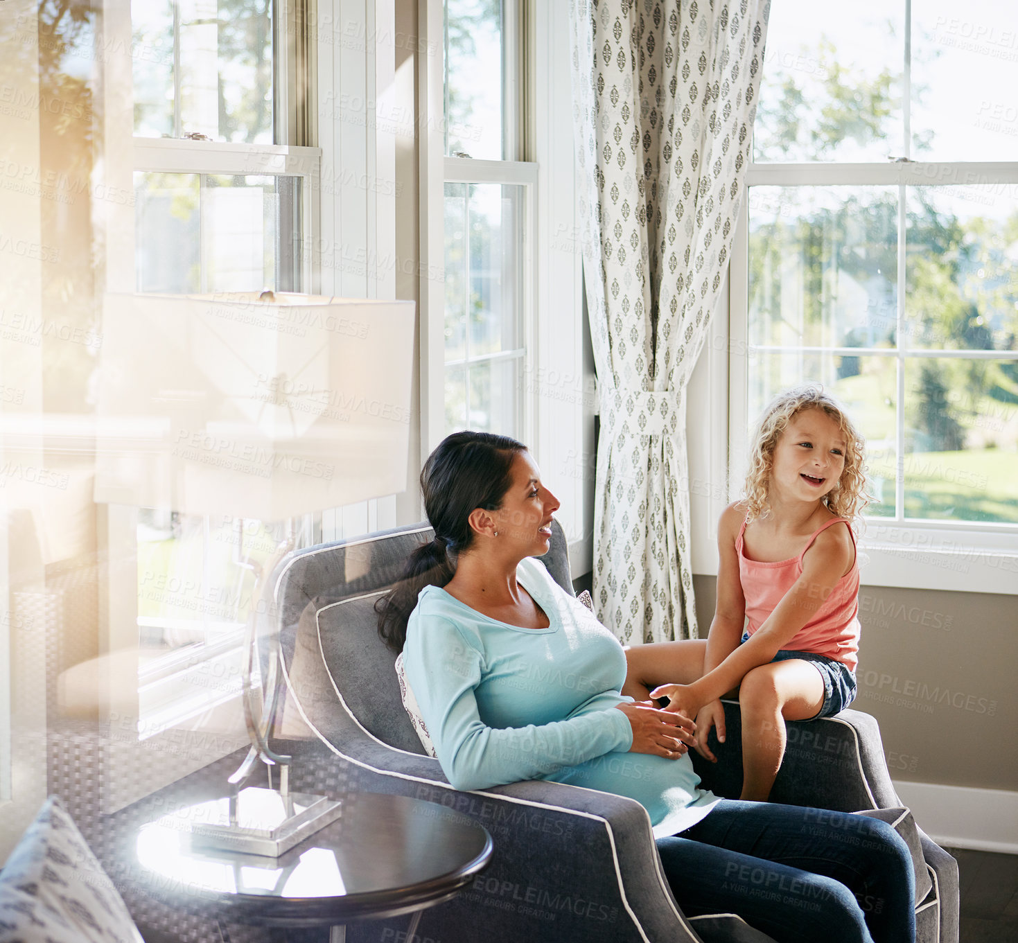 Buy stock photo Shot of a pregnant woman spending time with her daughter at home